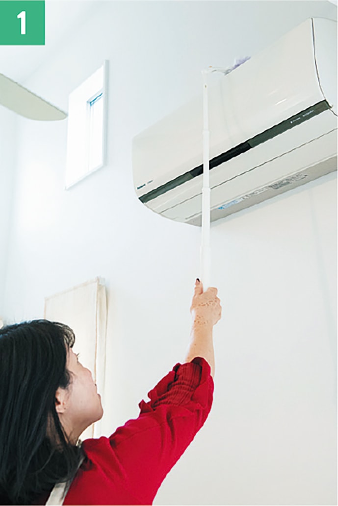 1_エアコンの上部の通気口は、伸びるタイプのお掃除ワイパーでほこりを取る。