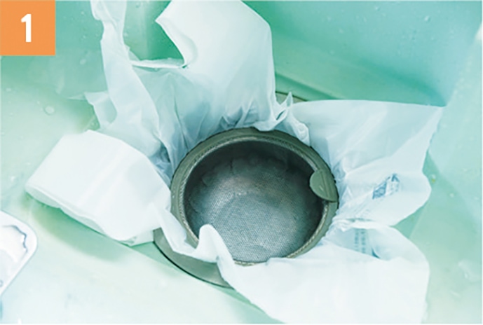 排水口にポリ袋を被せてゴミ受けを置き、シンクに６０℃のお湯をためる。