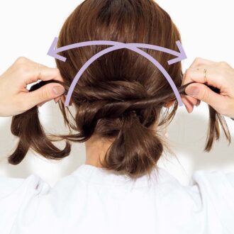 【2】おろしている髪を半分に分け、それぞれの毛束をねじりながら、お団子の根元に巻き付ける。