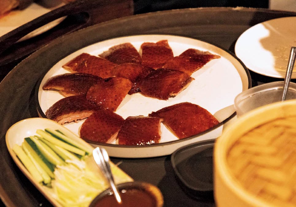 最初にカットされた油が少ない皮をこの店では跳跳糖という砂糖と包んで食べる。「口の中でパチパチ音がして砂糖が弾ける！」。お肉は甘辛い味わいに。