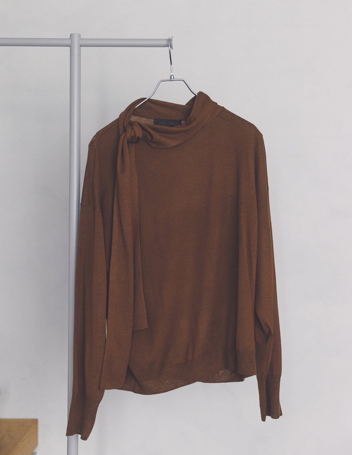 襟元のボウタイリボンをアレンジして表情変化を楽しめる。アクセいらずで顔周りが華やぎ、マニッシュ見えしつつもドレッシーな印象を与えられる。ニット（ザラ／ザラ カスタマーサービス）