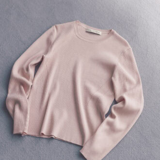 マイルドなピンクが肌になじみ血色感をアップ。窮屈さのない着心地のよさとスタンダードなデザインで、オンオフ着まわせる。ニット（ナノ・ユニバース／ナノ・ユニバースカスタマーサービス）