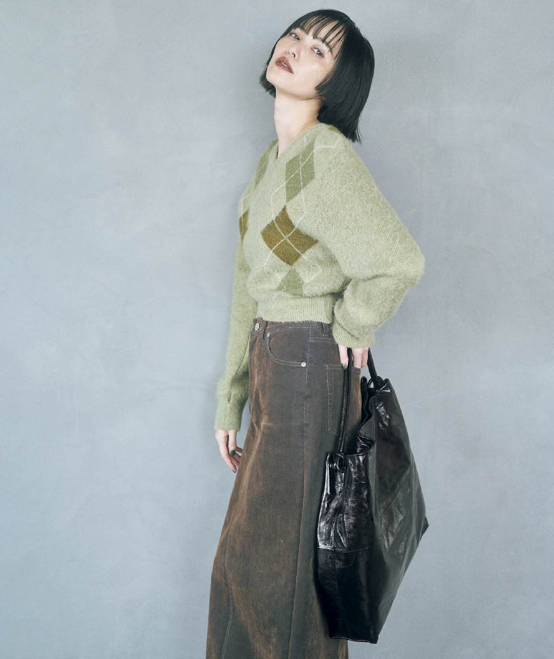 デニムにブラウンのフロッキー加工を施した色合いが新鮮なタイトめのスカートで、カジュアルトラッドなニットをすっきりとモダンに。スカート¥28,600（ウィム ガゼット／ウィム ガゼット ルミネ新宿店）　ニット¥47,300（ジェーン スミス／シップス インフォメーションセンター）　バッグ¥63,800（フィール アンド テイスト／アダム エ ロペ）