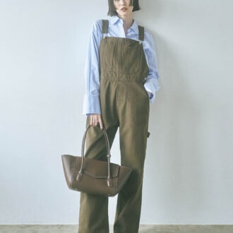 カジュアルな印象が強いブラウンのオーバーオールには、あえてクールなストライプシャツをセット。きちんと感とシャープな雰囲気が加わり、ほっこり見えを防いでくれる。オーバーオール¥8,900(NOKCHA) ストライプシャツ¥29,700(エモエレ/アダム エ ロペ) バッグ¥23,100(アンドミューク/アダムエロペ) シューズ¥83,600(ペリーコ/アマン)