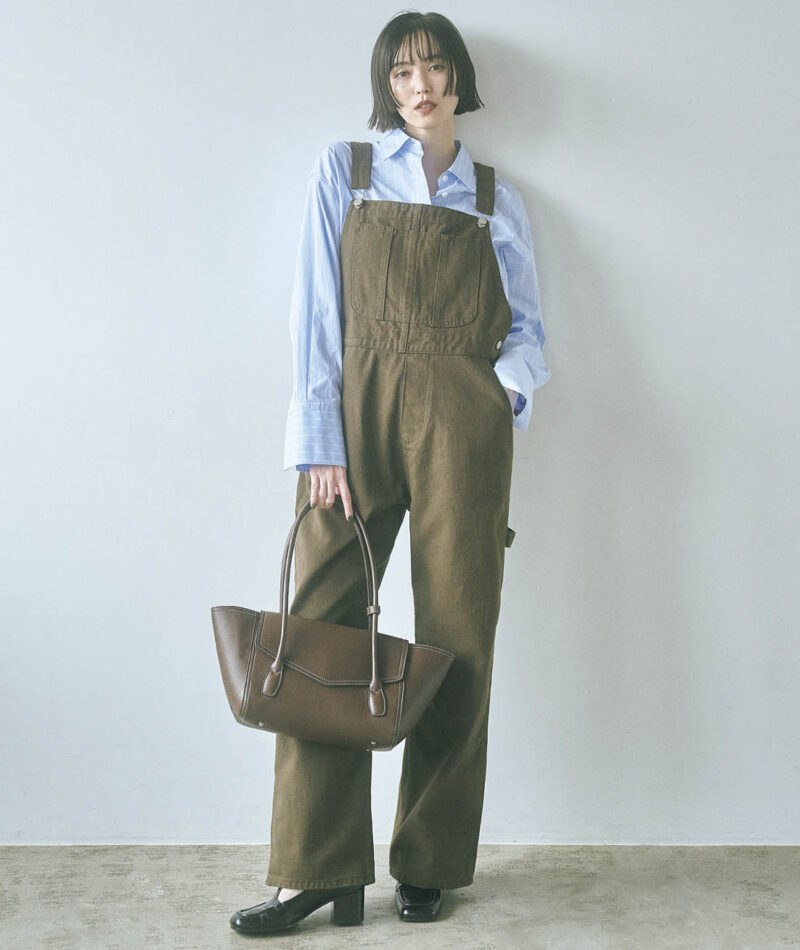 カジュアルな印象が強いブラウンのオーバーオールには、あえてクールなストライプシャツをセット。きちんと感とシャープな雰囲気が加わり、ほっこり見えを防いでくれる。オーバーオール¥8,900(NOKCHA) ストライプシャツ¥29,700(エモエレ/アダム エ ロペ) バッグ¥23,100(アンドミューク/アダムエロペ) シューズ¥83,600(ペリーコ/アマン)