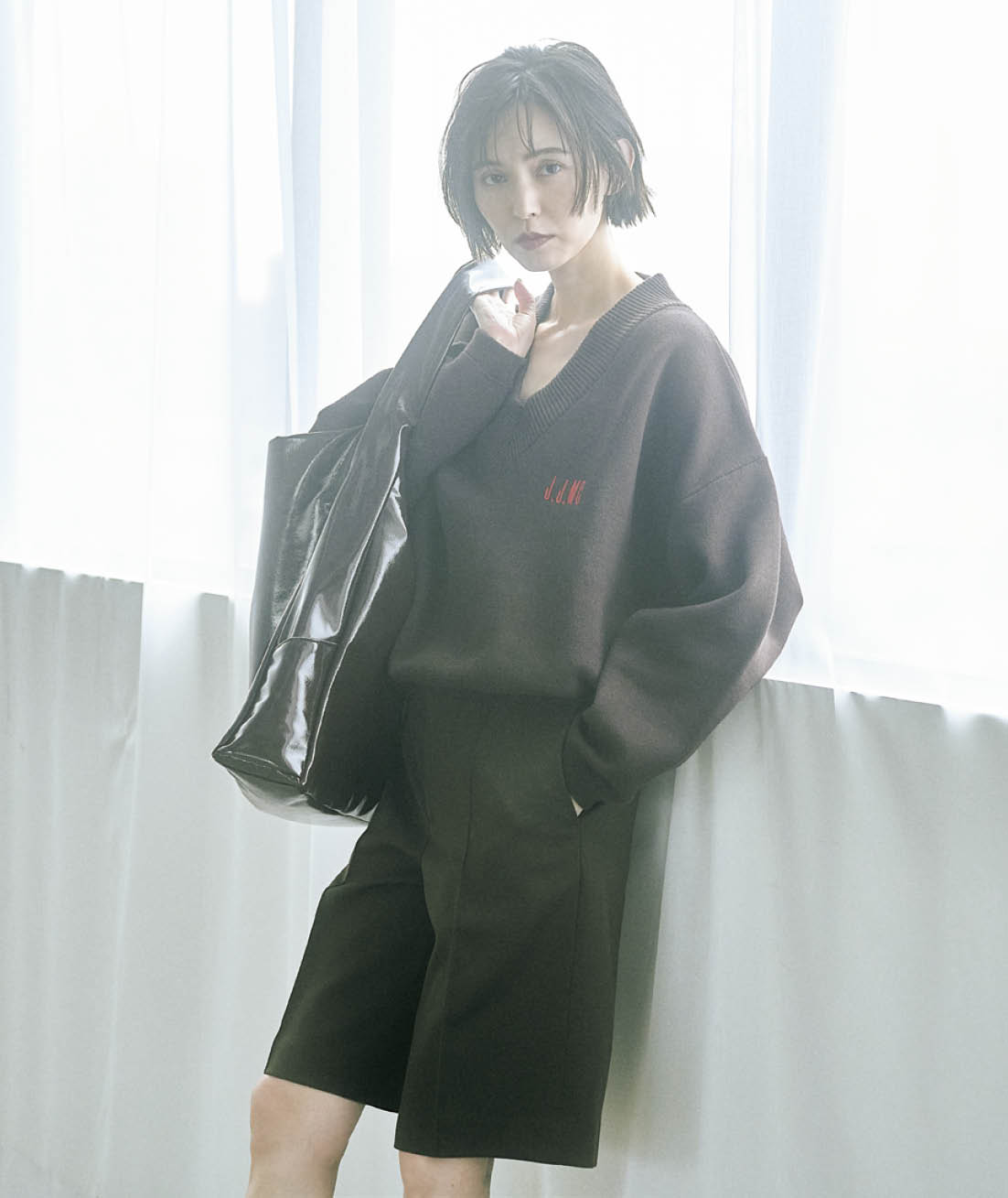 深Vで鎖骨やデコルテを、ハーフパンツで足を出して、こっくりしたブラウンとダークブラウンの組み合わせに抜け感を。バックの輝きでカジュアル感をはずして。ニット¥16,500(ジェイジェイマーサー×フリークス ストア/フリークス ストア渋谷) ハーフパンツ ¥32,450(ガジェス) バッグ¥20,900(アコック/ジャック・オブ・オール・トレーズ プレスルーム)