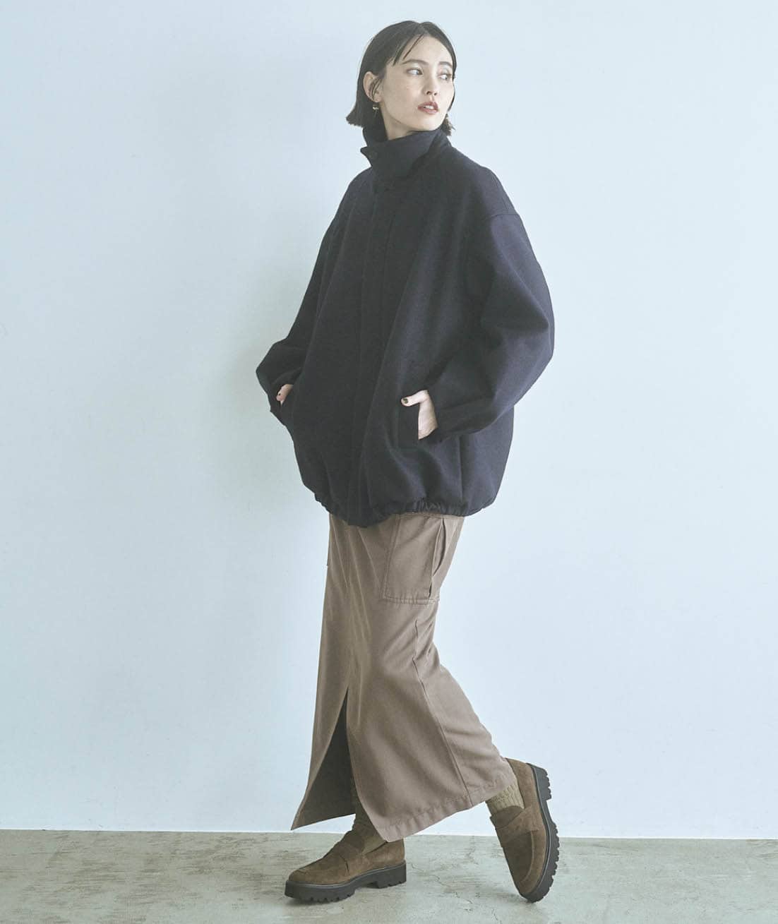 スレンダーなロングスカートでビッグブルゾンのフォルムを強調。色もフォルムもコントラストをきかせて洒落感をアップ。アウター（ファー襟付き）¥107,800（KAY LE）　スカート¥30,800（ウィム ガゼット／ウィム ガゼット ルミネ新宿店）　ピアス¥59,400（バウゴヘイアン） ローファー¥28,600（2.718／ガリャルダガランテ 青山店）　ソックス（スタイリスト私物）