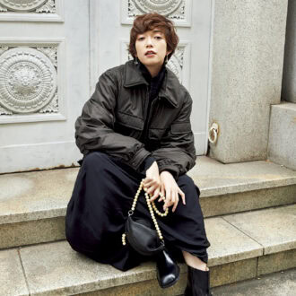 ブルゾン¥219,000、ニット¥92,000、スカート¥178,000、ピアス¥66,000、バッグ¥167,000、ブーツ¥154,000（すべてルメール／エドストローム オフィス）