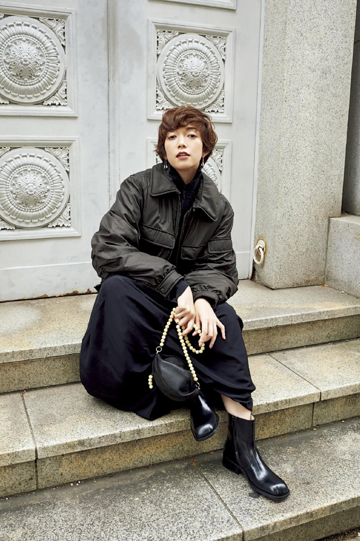 ブルゾン¥219,000、ニット¥92,000、スカート¥178,000、ピアス¥66,000、バッグ¥167,000、ブーツ¥154,000（すべてルメール／エドストローム オフィス）