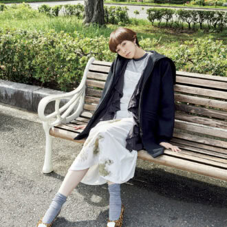 コート¥94,600（ハイク／ボウルズ）　中に着たブラウス¥39,600（ウーア／シップス インフォメーションセンター）　ジャンパースカート¥53,900（RH ヴィンテージ／ロンハーマン）　中に着たTシャツ¥7,700（オブラダ／シンチ）　ピアス¥20,900（ニナ·エ·ジュール／ショールーム ロイト）　パンプス¥79,200（ネブローニ／フラッパーズ）　ソックス（スタイリスト私物）