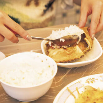 3.食べ進めたら味変もぜひ。甲羅のみそをかき集めたら白米をのせて、エゴマのすりごまとエゴマ油をかけたらかき混ぜて、のり巻きにして食べてみて。