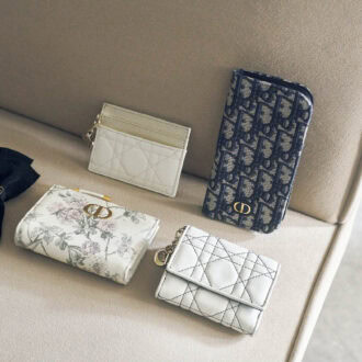 上段右から、“ディオール オブリーク”ジャカードを使用した手帳型。内側にはカード入れやポケットもあって機能的。スマホケース※iPhone16 Pro用￥97,000、アイボリー×ゴールドの洗練された配色と“カナージュ”ステッチが上品。取り外し可能な“D.I.O.R.”チャームも華やか。カードケース［H8×W10.5×D0.5、カード入れ5］￥65,000、下段右から、白×黒のコントラストがスタイリッシュ。コンパクトな三つ折りで手のなじみもグッド。日本限定。ウォレット［H8.5×W10×D2.5、カード入れ4］￥110,000、ムッシュのお気に入りの花を繊細なタッチと優しい色合いで描いたファンタジックなデザイン。日本限定。ウォレット［H9×W12×D2、カード入れ6］￥125,000、大きなリボンと“CD”シグネチャーを優雅なアクセントに。ヘアアクセサリー￥68,000（すべてディオール／クリスチャン ディオール）