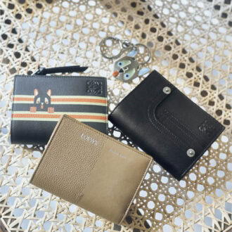 上から、ブルーの大きな目や耳、ぺろんと出した舌がファニー。シルバーカラーなので甘くなりすぎず、スタイリッシュにつけられそう。キーホルダー￥58,300、デニムのポケットやリベットを写したディテールが新鮮。美しいステッチを施した極上の仕上がりに職人技が宿る。ウォレット［H8・5×W11×D3、カード入れ6］￥115,500、オレンジ×アイボリーのダブルラインから顔を出す猫が愛らしい。インターシャ技法により耳や目、手などが立体的に浮かび上がる。ウォレット［H8・5×W11・4×D3、カード入れ6］￥115,500、シボとスムース、二つの表情の組み合わせがモダン。ウォレット［H8・5×W11・4×D3、カード入れ6］￥102,300（すべてロエベ／ロエベ ジャパン クライアントサービス）