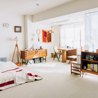 フローリングだったフロアにアイボリー色のカーペットタイルをDIYで敷き詰め、木目の家具が引き立つ空間に