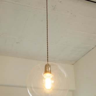 寝室の照明は、KANADEMONOのもの。存在感のあるガラスシェードに注目