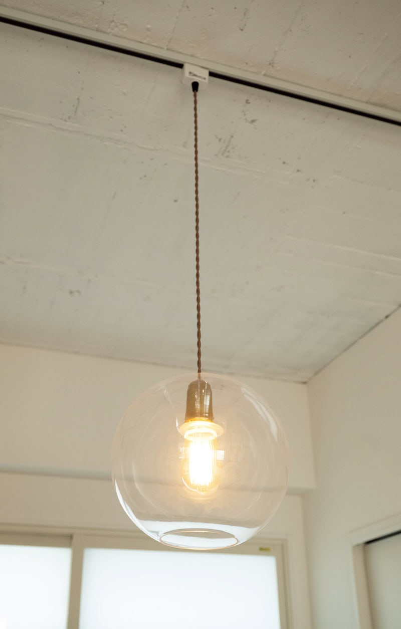 寝室の照明は、KANADEMONOのもの。存在感のあるガラスシェードに注目