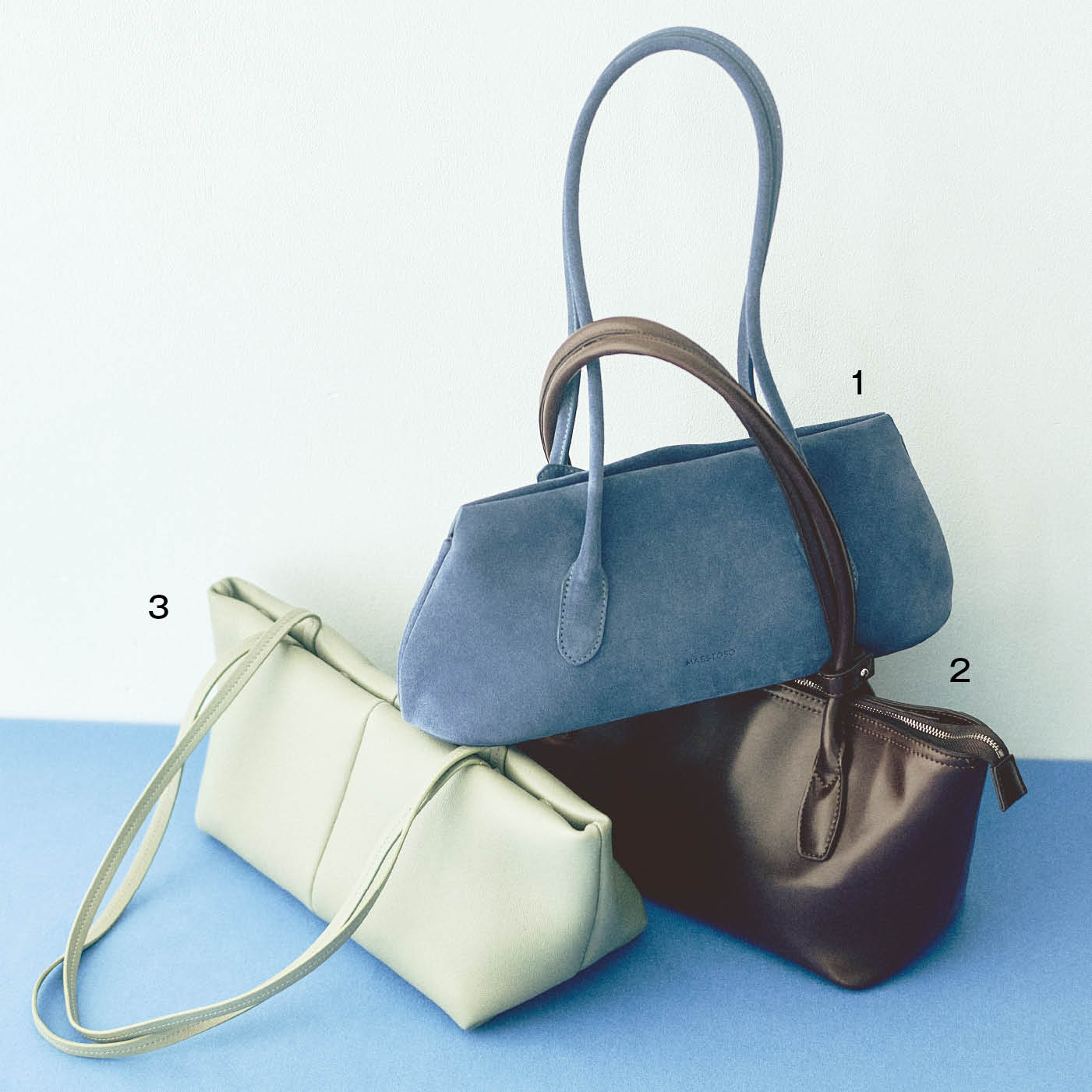 1. 春色とも相性のいいブルーのスウェード。厚みのないすっきりした形で肩掛けしてもきれいに収まる。バッグ[Ｈ14×Ｗ33×Ｄ9]¥93,500(マエストソ)、2. 艶やかで上品なブラウンがトレンド感たっぷり。クリーンな台形ボディで収納力があり、開口部がジッパー式で使い勝手のよさも上々。バッグ[H16×W39×D12]¥23,100(アンドミューク／ともにアマン) 　3. きれいな色や華やかな柄の服にもなじみやすいクリーム色。上質なレザーが作る丸みのあるシェイプと、センターの切り替えがモダンなアクセントになってくれる。バッグ[H14×W37×D14]¥96,800(メイデン／ギャルリー・ヴィー 丸の内店)