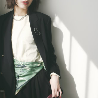 スカーフをベルトのように腰巻きする新たな視点。グリーンボンメールスカーフ￥22,000（マニプリ）　ブレザー￥19, 800（ジャーナル スタンダード レリューム／ジャーナル スタンダード レリューム ルミネ新宿店）　ロングTシャツ￥10,780（セカンドノーリーズ／ノーリーズ自由が丘店）　ハーフパンツ￥16,500（シップス／シップス インフォメーションセンター）　ネックレス￥60,500（リエ スタジオ／トゥモローランド）　ブローチ￥1,430（アネモネ／サンポークリエイト）　バッグ￥48,400（OSOI／OSOI SHINJUKU）