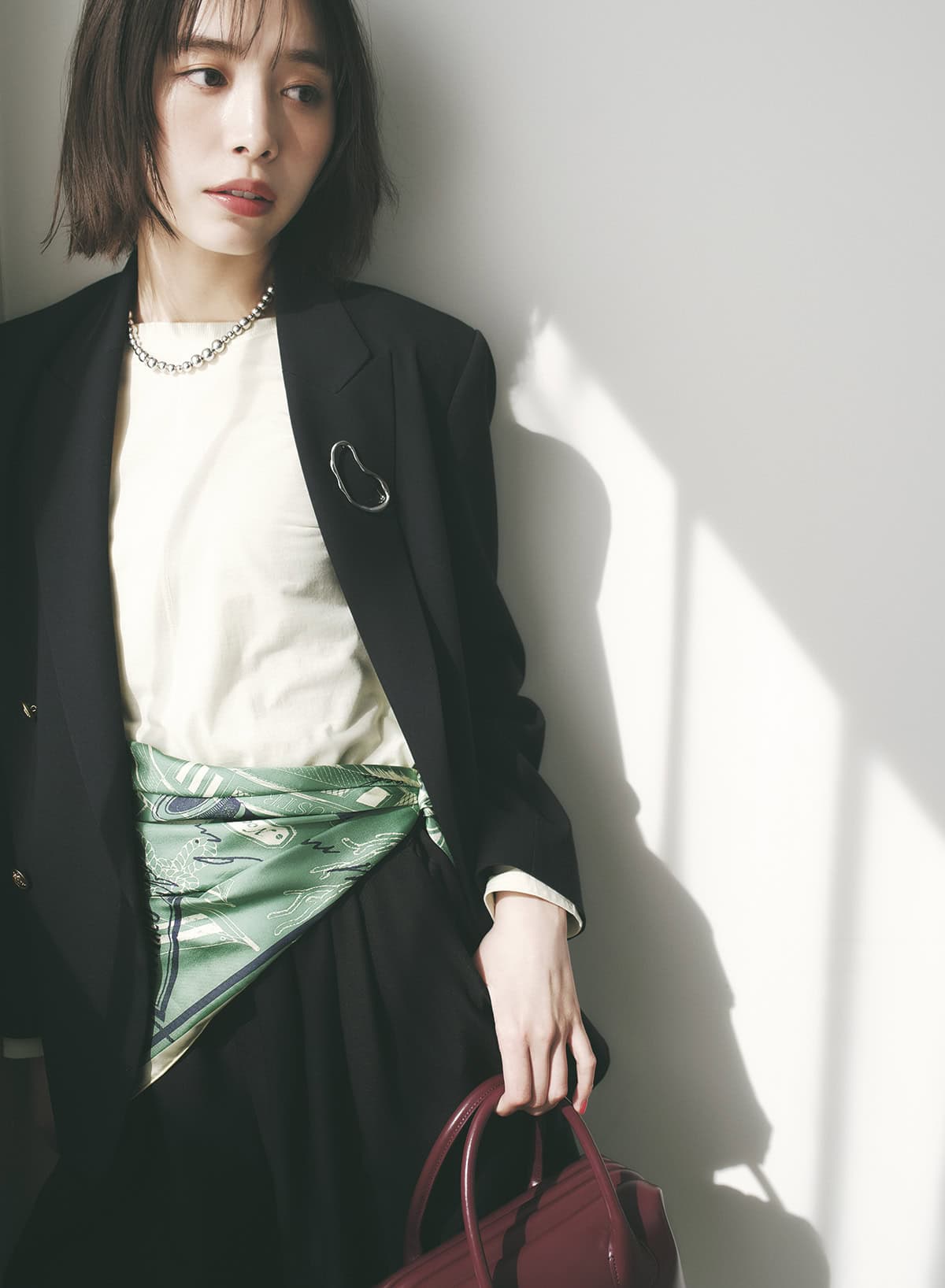 スカーフをベルトのように腰巻きする新たな視点。グリーンボンメールスカーフ￥22,000（マニプリ）　ブレザー￥19, 800（ジャーナル スタンダード レリューム／ジャーナル スタンダード レリューム ルミネ新宿店）　ロングTシャツ￥10,780（セカンドノーリーズ／ノーリーズ自由が丘店）　ハーフパンツ￥16,500（シップス／シップス インフォメーションセンター）　ネックレス￥60,500（リエ スタジオ／トゥモローランド）　ブローチ￥1,430（アネモネ／サンポークリエイト）　バッグ￥48,400（OSOI／OSOI SHINJUKU）