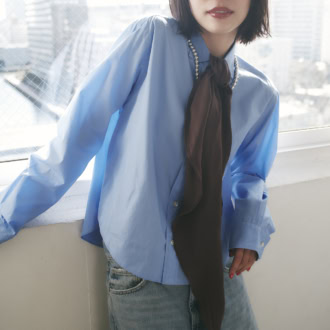 ショート丈シャツに、ボウタイのように結んだ縦へと流れるロングスカーフが、シルクならではのなめらかさと柔和な華やぎ、旬を同時に宿す。ブラウンシルクスカーフ￥12,100（サロン アダム エ ロペ）　ネックレス￥58,080（ペヨテ・バード・デザイン／ズットホリック）　シャツ￥19,800（ザ シンゾーン／シンゾーン ルミネ新宿店）　デニムパンツ￥7,990（ザラ／ザラ カスタマーサービス）