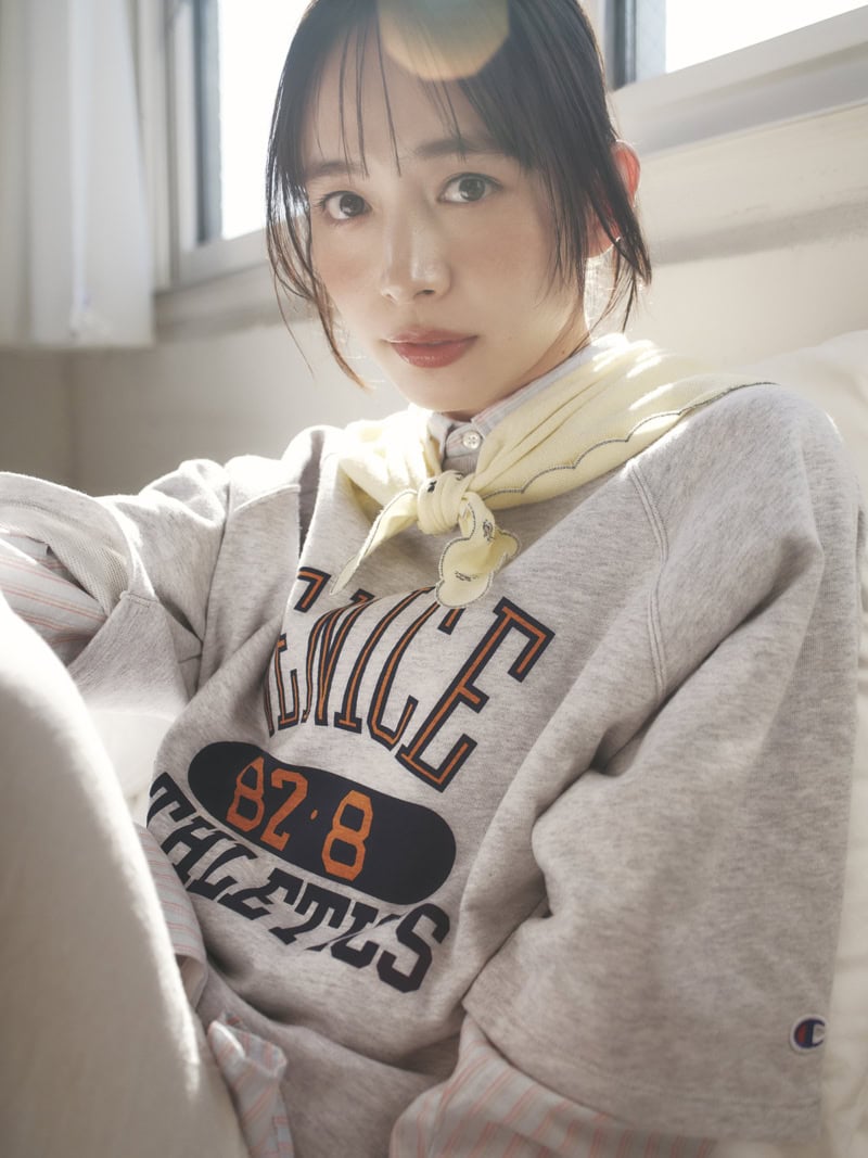 コンパクトめのスカーフを首にキュッと巻いて甘さをトッピング。カジュアルなカレッジロゴスウェットと相反するフェミニンなスカラップスカーフでMIX感を楽しんで。スカーフ￥33,000（ババコ／Orchard Lane Co.,Ltd.）　ストライプシャツ￥50,600（インディヴィジュアライズドシャツ／サロン アダム エ ロペ）　半袖スウェットプルオーバー￥7,920（チャンピオン／ジャーナル スタンダード レリューム ルミネ新宿店）　スカート￥28,600（エス／sense）