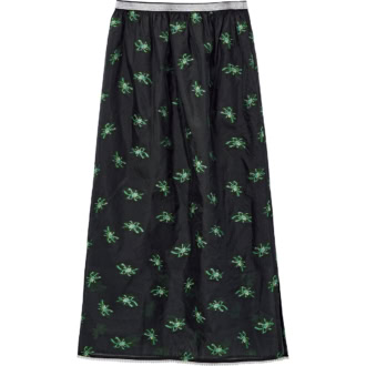 ブラックに映えるグリーンの柄と、透け感や揺れ軽やかに華やぐ。スカート￥20,900（ホワイト）