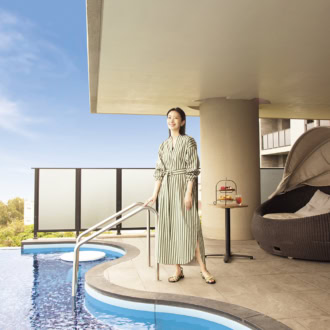 グランディスタイル沖縄読谷ホテル＆リゾートのプール。プールサイドに立つ波瑠さん