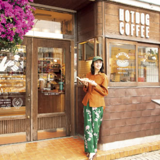 本格ドイツ製法で作るハム、ソーセージの専門店「TESIO」の前でホットドッグを手に持つ波瑠さん