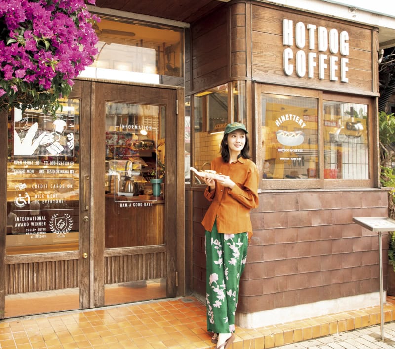 本格ドイツ製法で作るハム、ソーセージの専門店「TESIO」の前でホットドッグを手に持つ波瑠さん