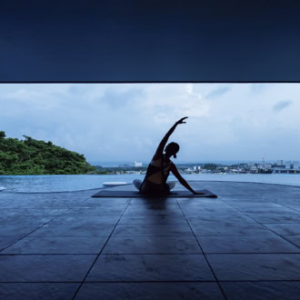 プールサイドでヨガをする女性