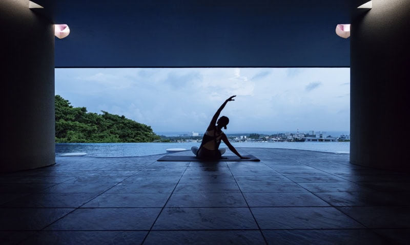 プールサイドでヨガをする女性