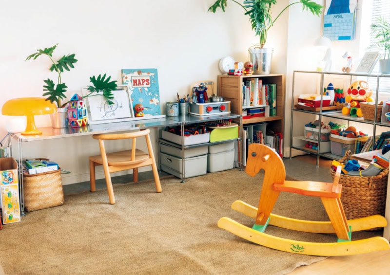 リビングとつながる子ども部屋。THE FRIGGのラックにおもちゃを見せる収納。ベースを直線的でモダンなスチール家具にすることで、カラフルなおもちゃもポップな雑貨もなじむ。この工夫がお見事! アンパンマンのオレンジ色が全体にさりげなく散りばめられていることにも注目。