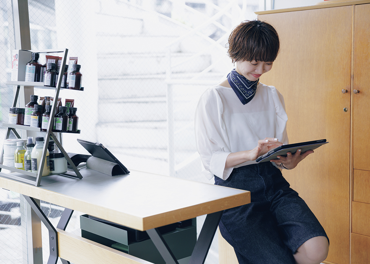 InRed Icons 美容師の丸岡奈央さんのお仕事風景。予約を確認しながら3店舗の状況を把握